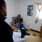 Clyde Brown watches his son, Mateo, play a video game on his Nintendo Wii. Brown said his job at Plain Green made it easier to provide luxuries and amenities for his family.