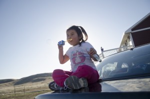 Nevaeh Fisher, 4, blows bubbles outside of her great-grandmother Elizabeth Stewart’s home in Crow Agency. Stewart secured the home through the Section 184 Indian Home Loan Guarantee Program.