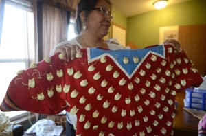 Mandy Plainfeather, 41, shows off an elk-ivory dress she made for her daughter in her home outside of Lodge Grass. Plainfeather said she likes the extra space her new home gives her for dressmaking.
