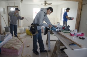 Electrician Barry Glen, left, crew member Isaiah Dust, center, and head carpenter Chris Cole work on a house in Lodge Grass. As part of the renovation, the crew is making the house more handicap accessible for the elderly occupant.