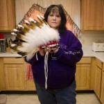 Amy Headdress DeHerrera stands with a headdress she made for her youngest son.  The headdress was stolen over a year ago, but DeHerrera recently recovered it when someone tried selling it on the Fort Peck Rez Online Yard Sale Facebook group. She founded the group several years ago as an online arena for people to buy, sell and trade goods and services.