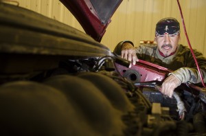 Lenny Gray Wolf inspects the engine compartment of a Ford Windstar. Gray Wolf has been working on cars since his childhood, a skill that now provides him with extra income and fills a niche in the community for inexpensive car work.