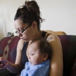 Brittany Deavila, 19, holds her 2-month-old baby O’Ryan in her Wolf Point apartment. Deavila is waiting to buy a high chair she found on the Facebook group, Fort Peck Rez Online Yard Sale, for $40. The chair is too big for O’Ryan now, but Deavila says he will soon grow into it.