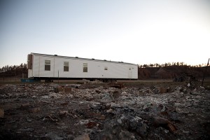 A FEMA trailer sits behind the Bartlett’s new home where their work sheds used to be. It is one of several trailers acquired by the Northern Cheyenne Tribal Housing Authority. Almost a year after the Ash Creek Fire blazed through the reservation debris remains to be cleared.