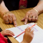 Geraldine Doney helps Gregory Gardipee write his name at Fort Belknap Head Start. As a volunteer, Doney is an extra set of eyes and hands to help teach the kids. She says the kids today aren't as eager to learn as they were when she started at the school.