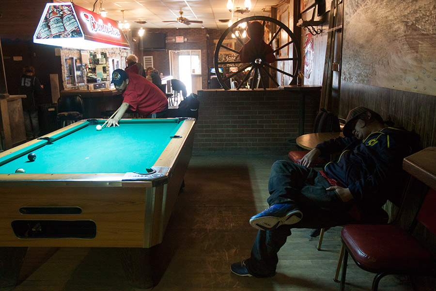 Ryan White Horse takes a nap during his friend Melvin Martell’s 2 p.m. pool game at Arlo’s Bar in Wolf Point.