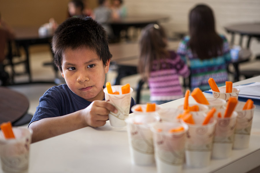 "I hate carrots,” says 6-year-old Max Littlebird as he reaches for a healthy snack at the Boys & Girls Club of the Northern Cheyenne Nation. The club's food is funded by a program that requires it to serve healthy foods to kids, such as carrots with ranch dressing.