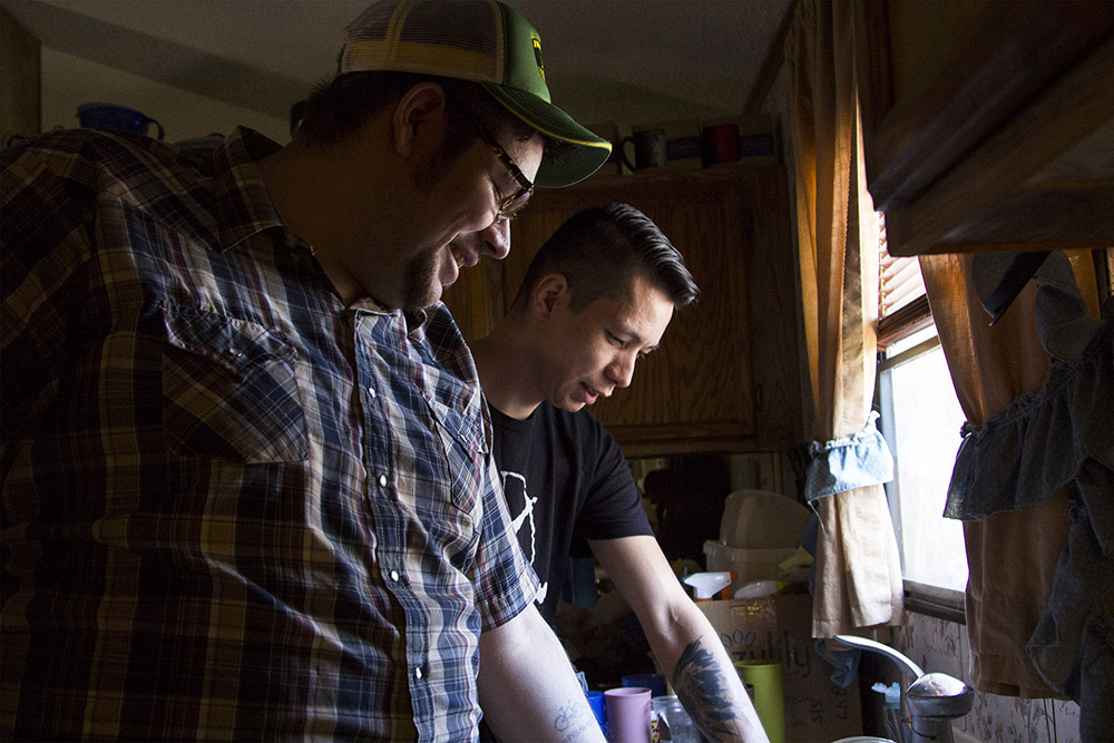 Eddie Bauer, left, and his brother Francis Bauer clean the dishes at their uncle’s house. Eddie lives with his uncle and keeps the house clean in return for a room.
