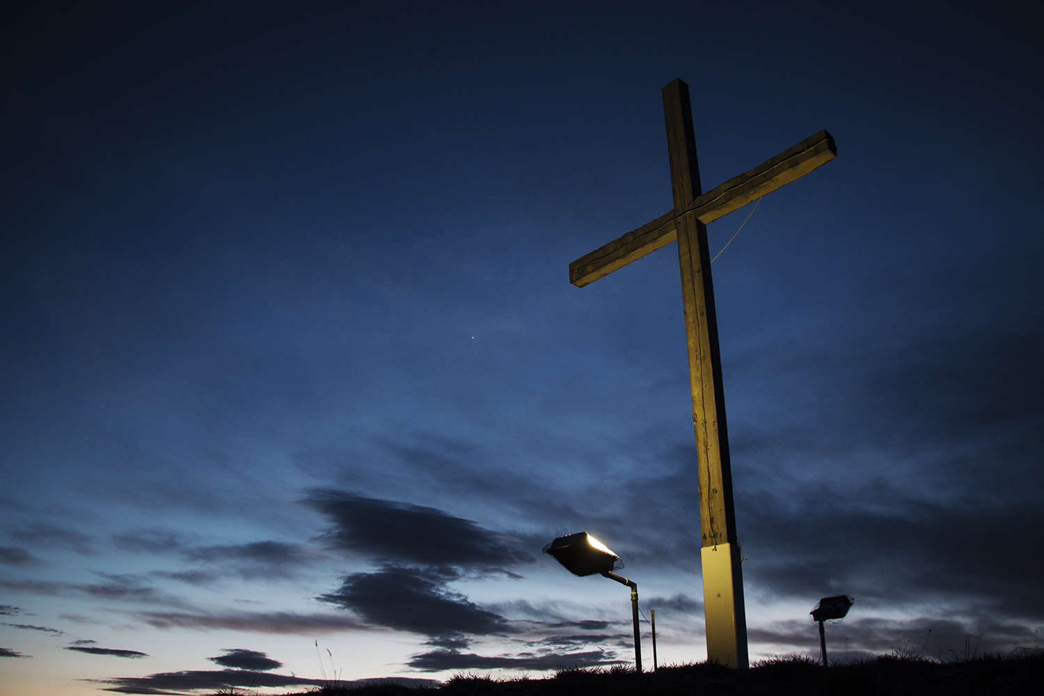 A cross stands at the top of a hill overlooking Crow Agency.