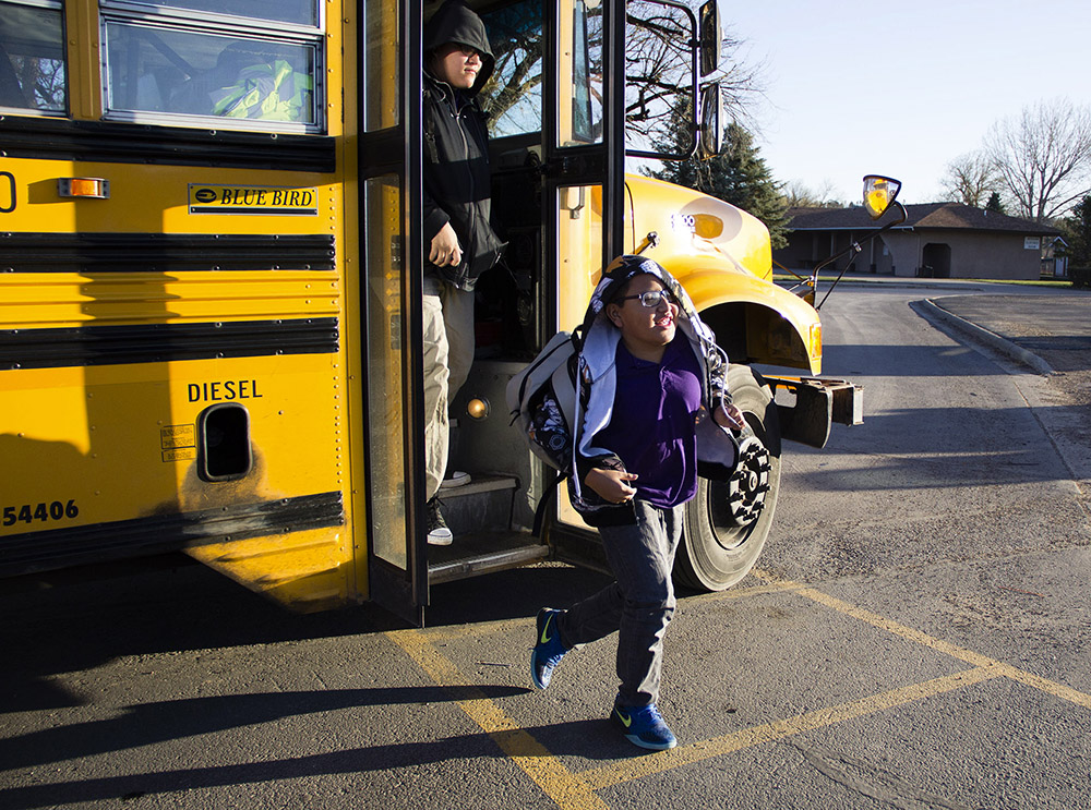 Sheldon King Jr., 8, jumps off the bus and heads toward school. Sheldon and his sister have thrived at St. Labre Indian School. They are both two grades ahead in their reading level.