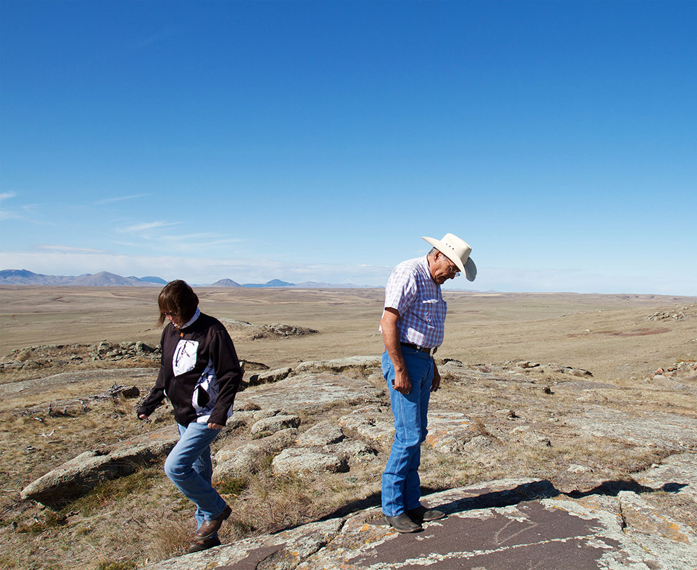 Stephanie and Ivan Wing study the pictographs in a buffalo pasture beneath the Little Rocky Mountains. The Wings know every inch of Fort Belknap Reservation.