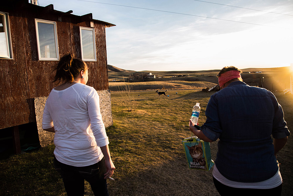 Aimee Montes, left, and her sister Javon Wing walk to watch the sunset and throw a ball for the family dog, Shooter.