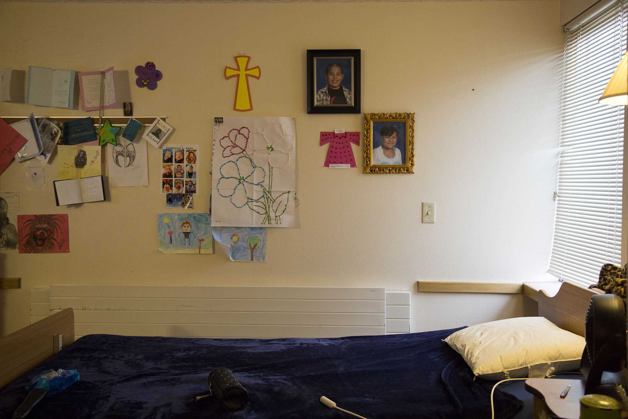 Pictures and drawings by grandchildren cover TroyLnn Shotgunn’s wall in her room at the Awe Kualawaache Care Center.