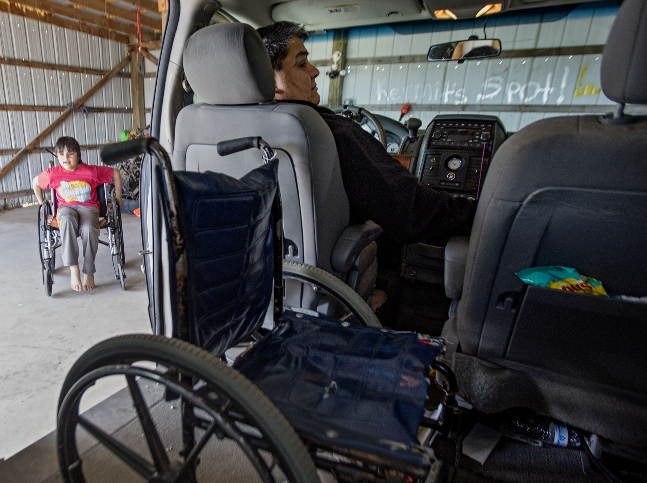 Kermit Horn parks his van at his home on the Fort Belknap Indian Reservation while his grandson Kayden Castillo plays in Horn’s other wheelchair.