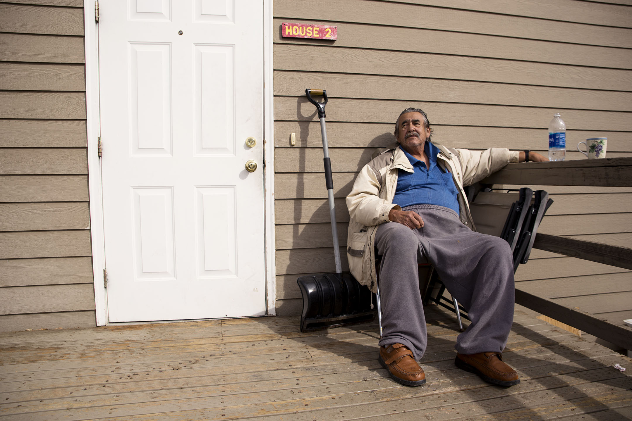 Mitchell Headdress smokes a cigarette on the front porch of the Fort Peck Warriors Center as he waits for his ride to take him to an appointment at the VA in Miles City. He doesn’t have a television or radio, so he spends much of his time sitting outside or reading.