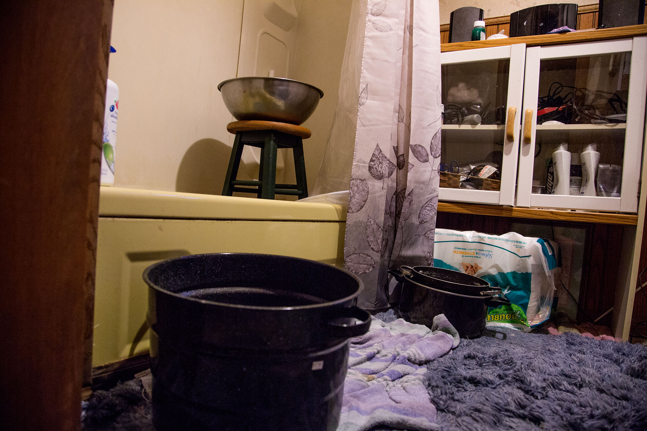 Leana Wright boils a large pot of water and carries it to her bathroom every evening to bathe. She then mixes the boiled water with a pot of cooler water to get the right temperature. The bowl placed on top of the stool is strictly for rinsing. “It’s just like a shower,” Wright said.